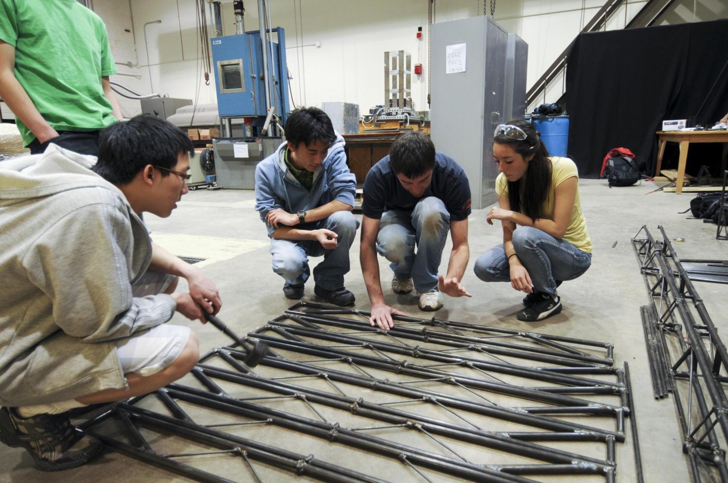 A group of students discuss the design of their steel bridge.