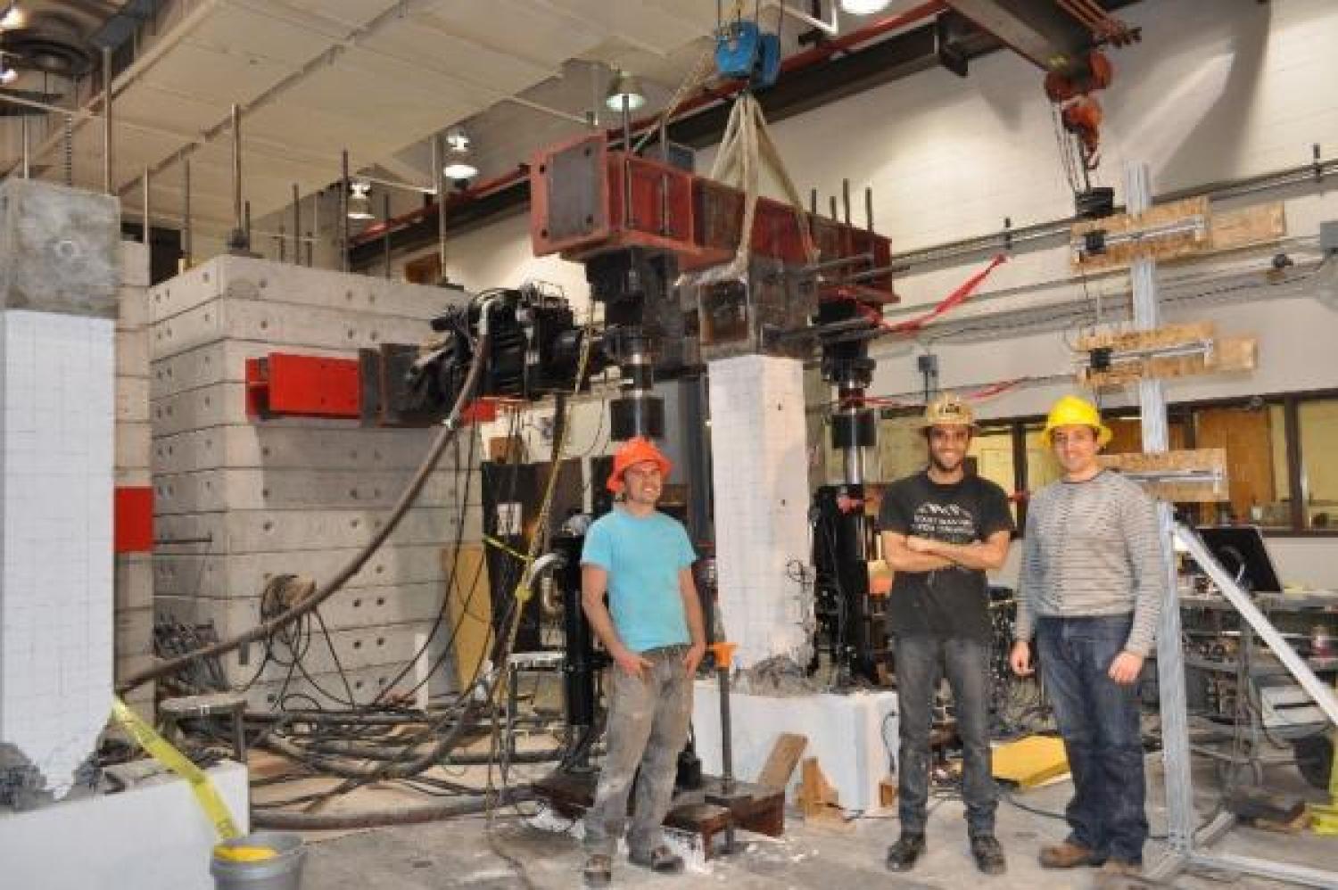 The project team with a concrete column in the loading frame.