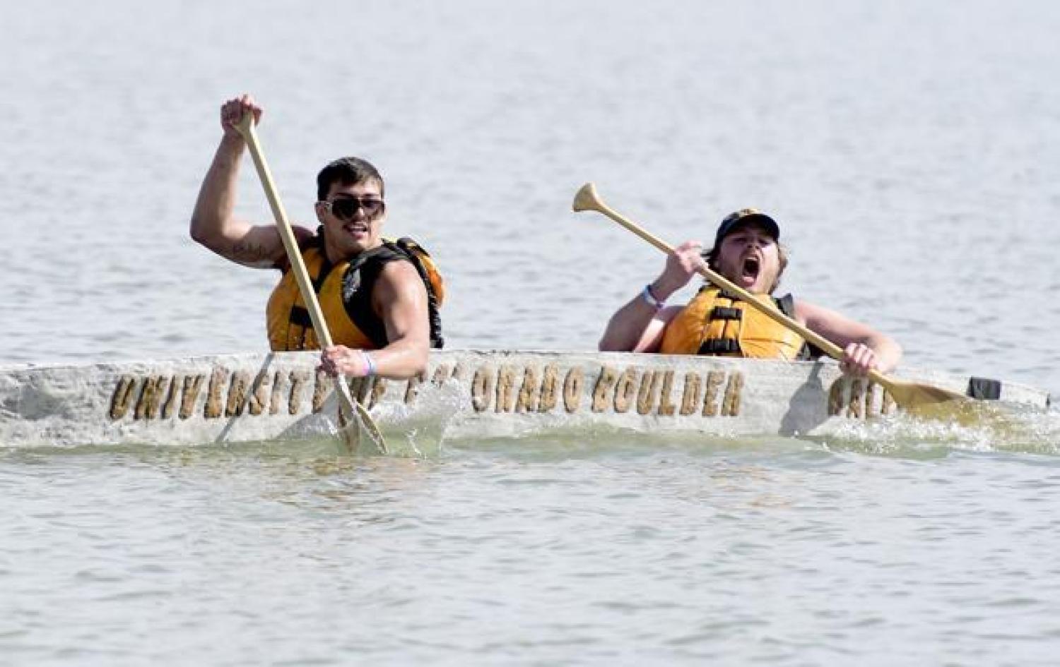 Two students paddle towards the finish in their concrete canoe