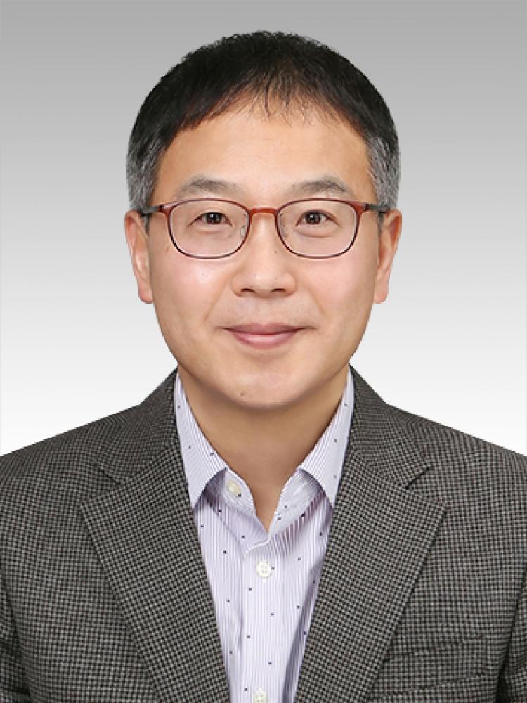 Sam Sohn wearing glasses. He is in a suit jacket and button-down shirt.