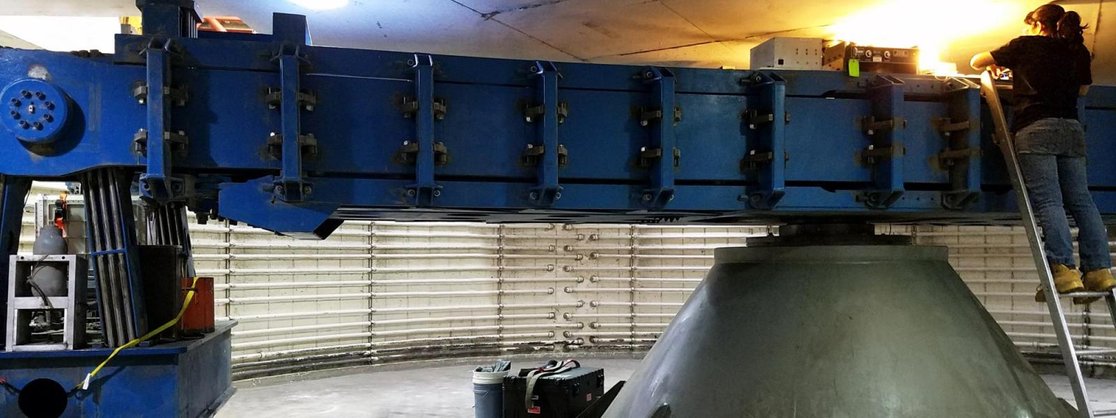 A student works on the top of the centrifuge arm