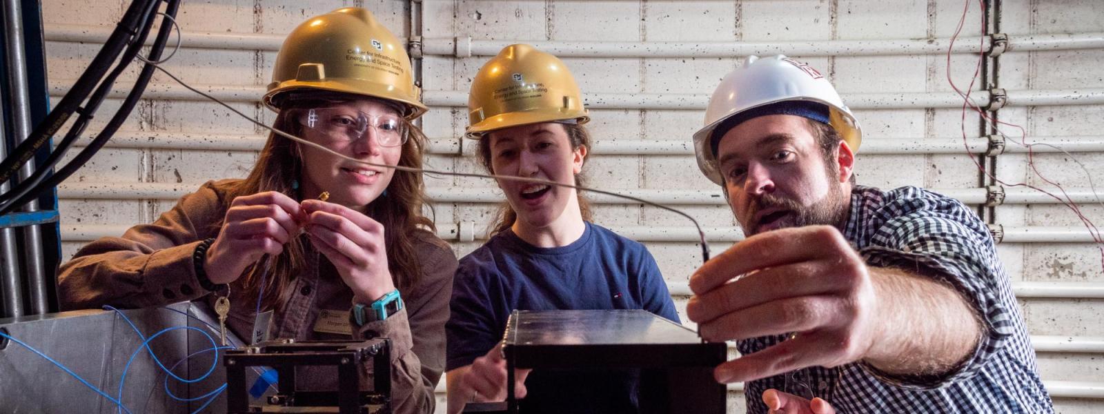 CIEST team members wiring a model structure on the shake table of a centrifuge