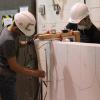 Two students cut Styrofoam to make the mold for the concrete canoe