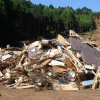 A car sits mired in the mud next to a destroyed building in a Japanese town where earthquakes triggered mudslides