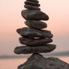 photo of stacked rocks with a pink sky