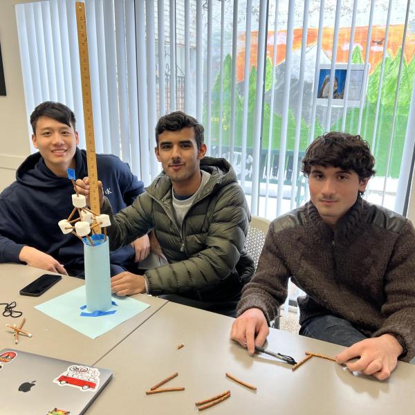 Students building a tower out of pretzels, marshmallows and papers.