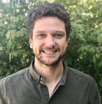 Carlo Salivenlli standing in front of leaves