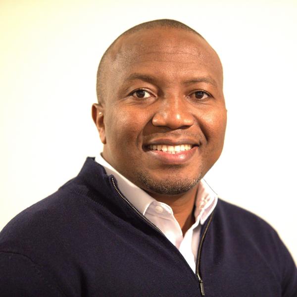Man smiles in dark sweater