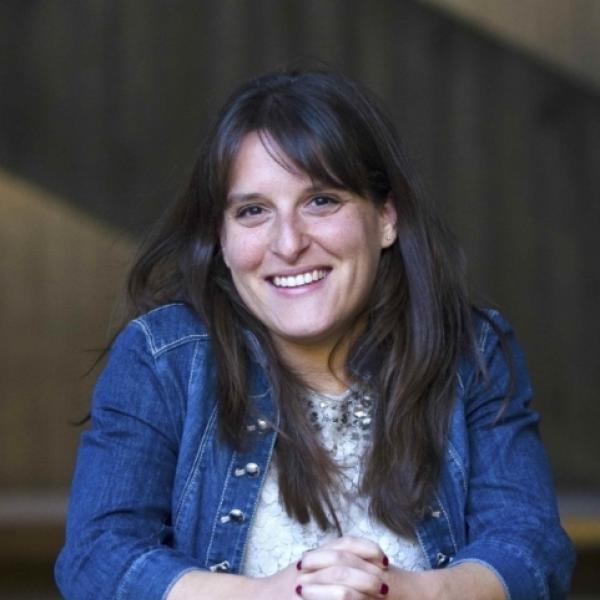 Dr Abbie Liel smiling and resting her arms on a table