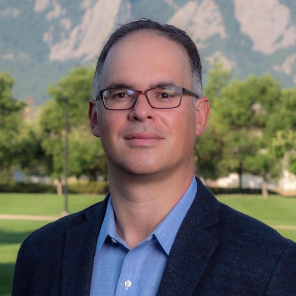 Headshot of Fernando Rosario-Ortiz with flatirons in the background