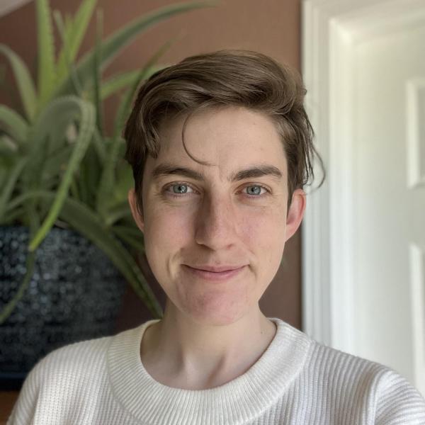 Laura Hamrick smiling in a white sweater with plants in the background