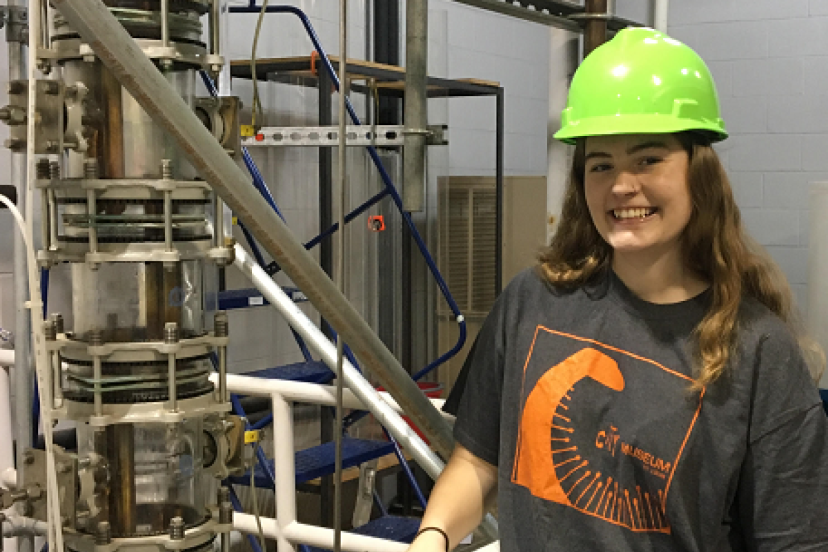 Student standing in front of pipes