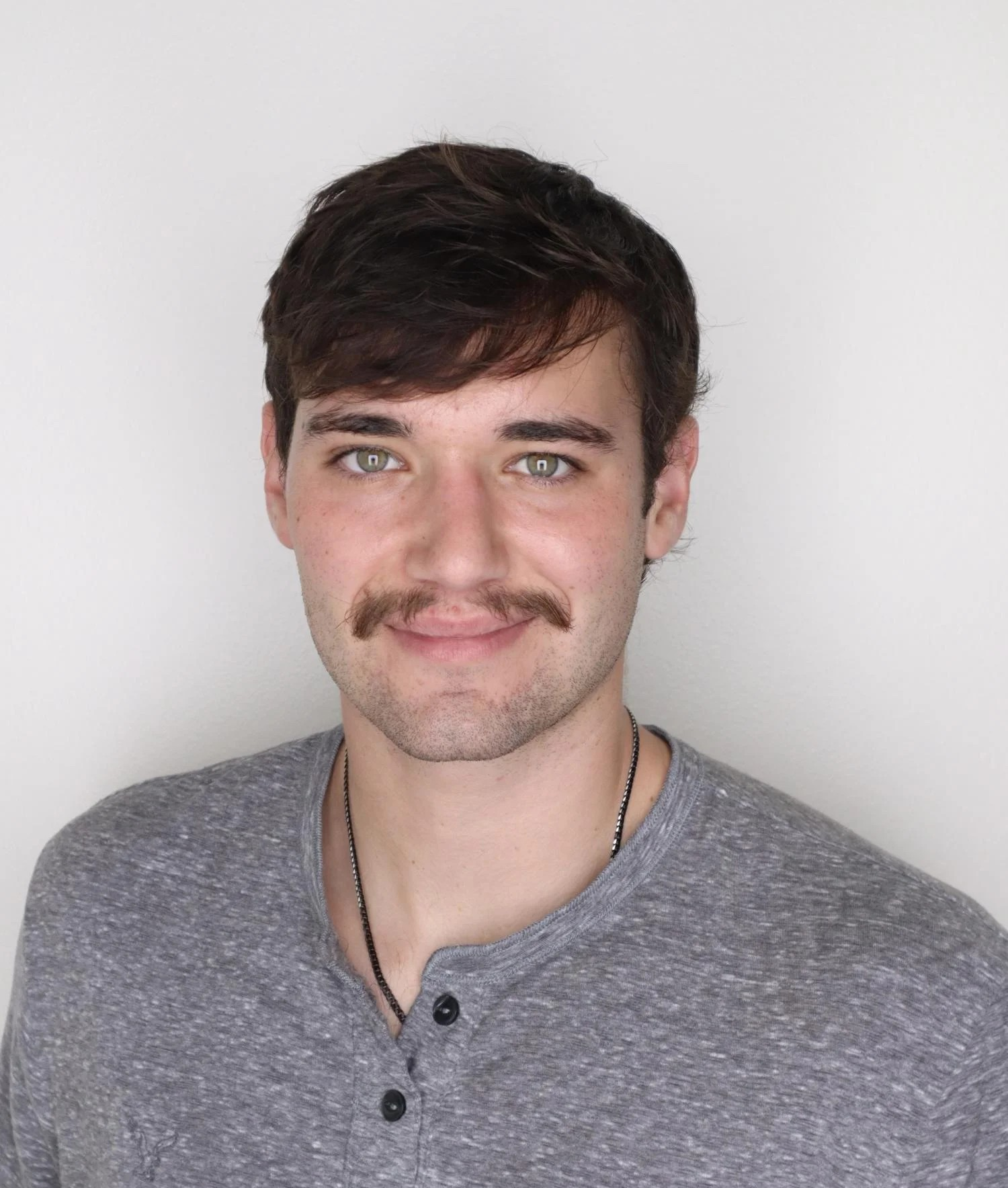 Man with mustache wears grey shirt