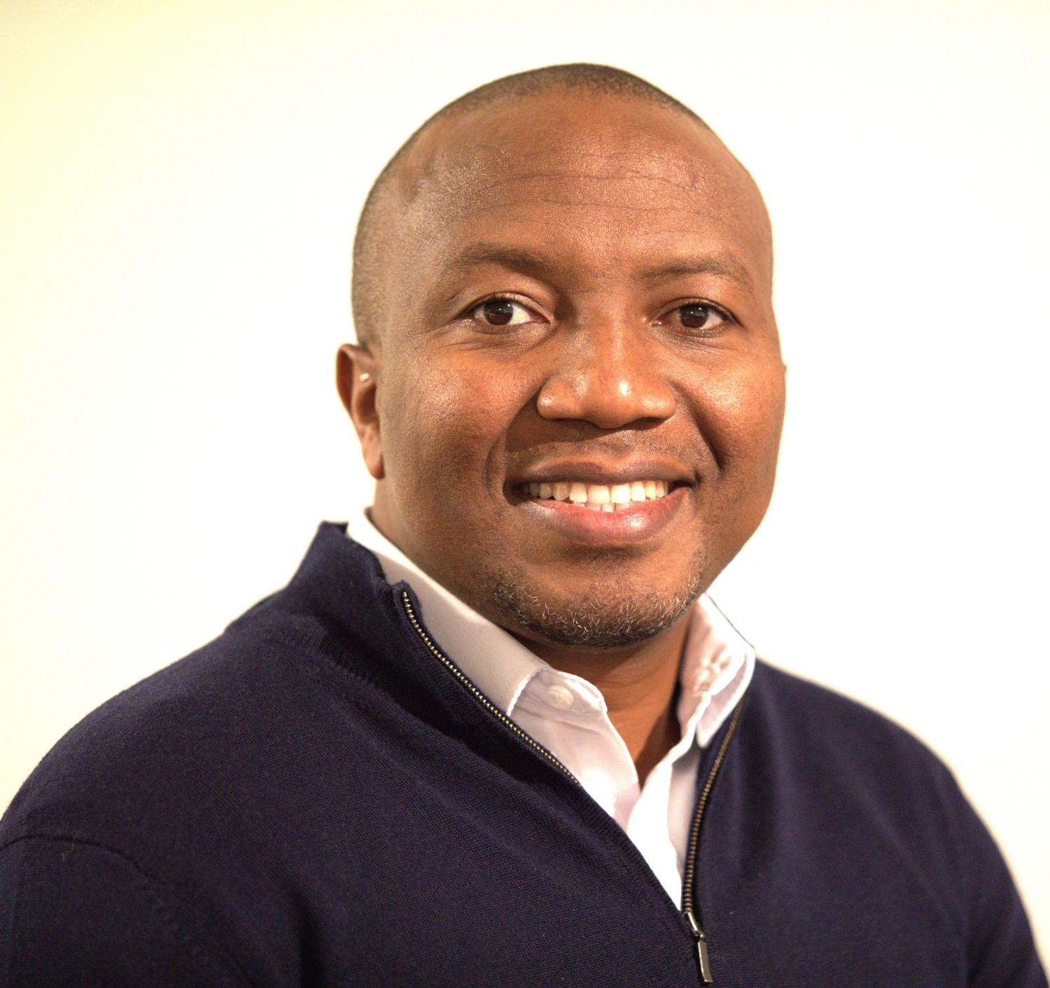 Man smiles in dark sweater