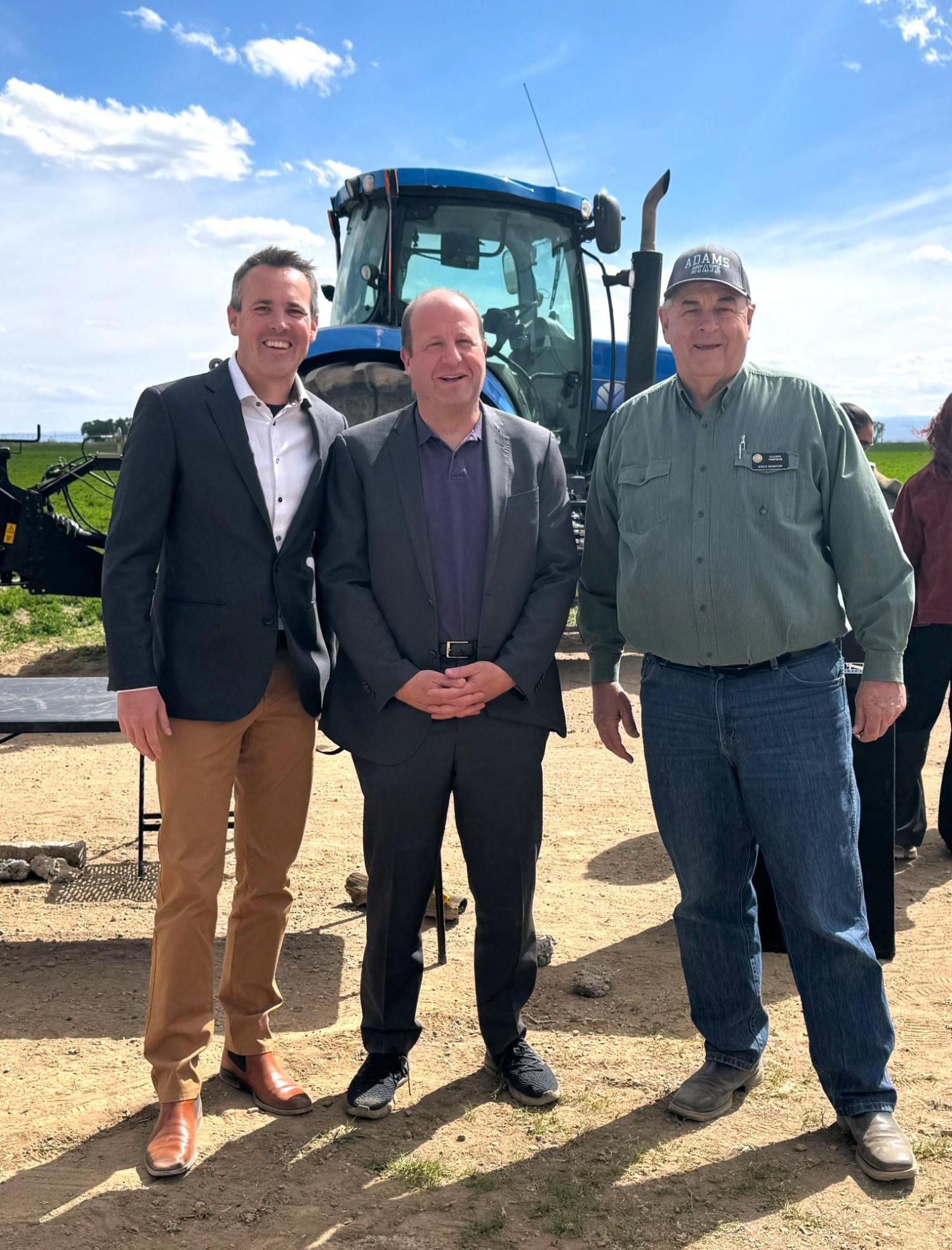 The professor Evan Thomas with the governor and a senator in a field outside