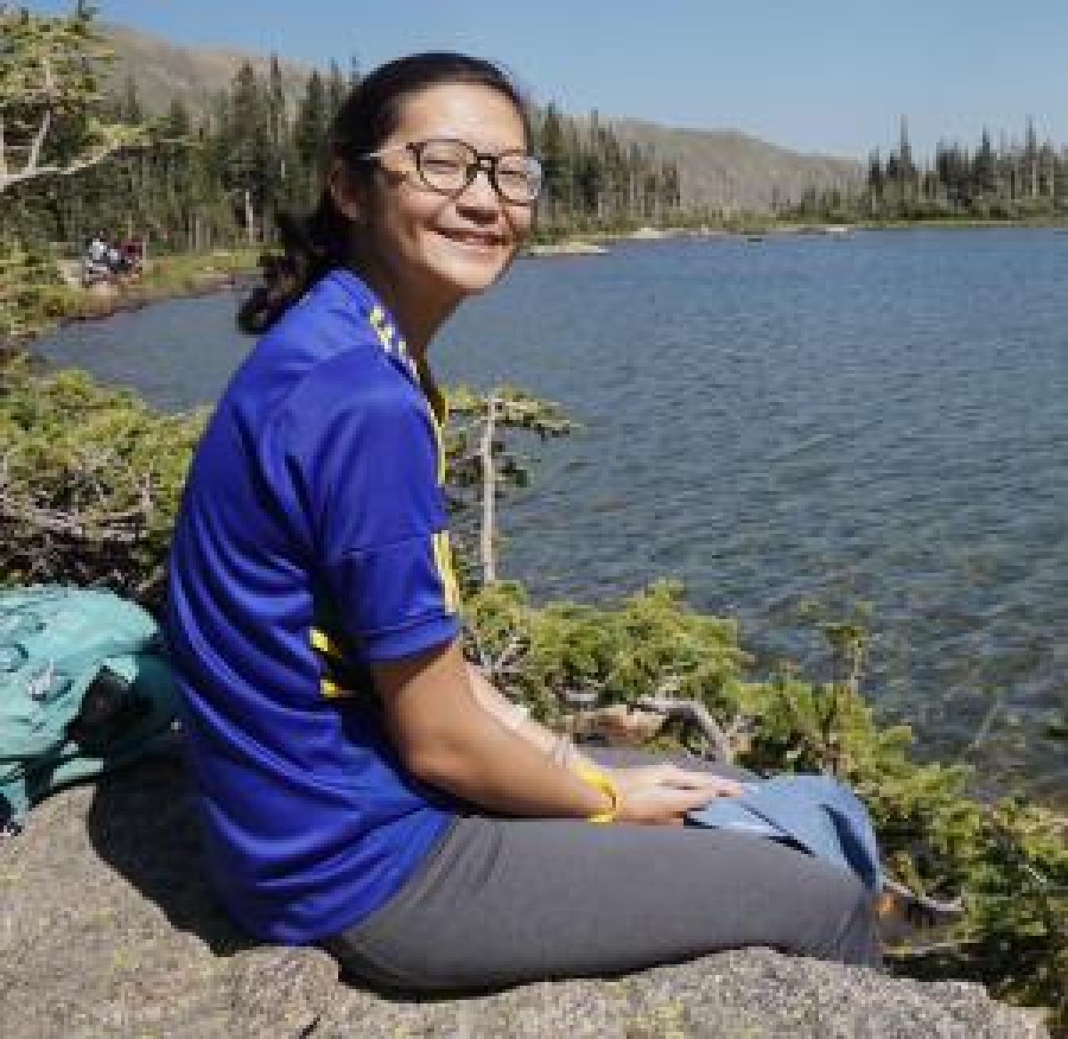 Naomi sits next to lake