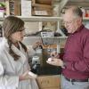 Professor Karl Linden shows a woman in a lab some equipment