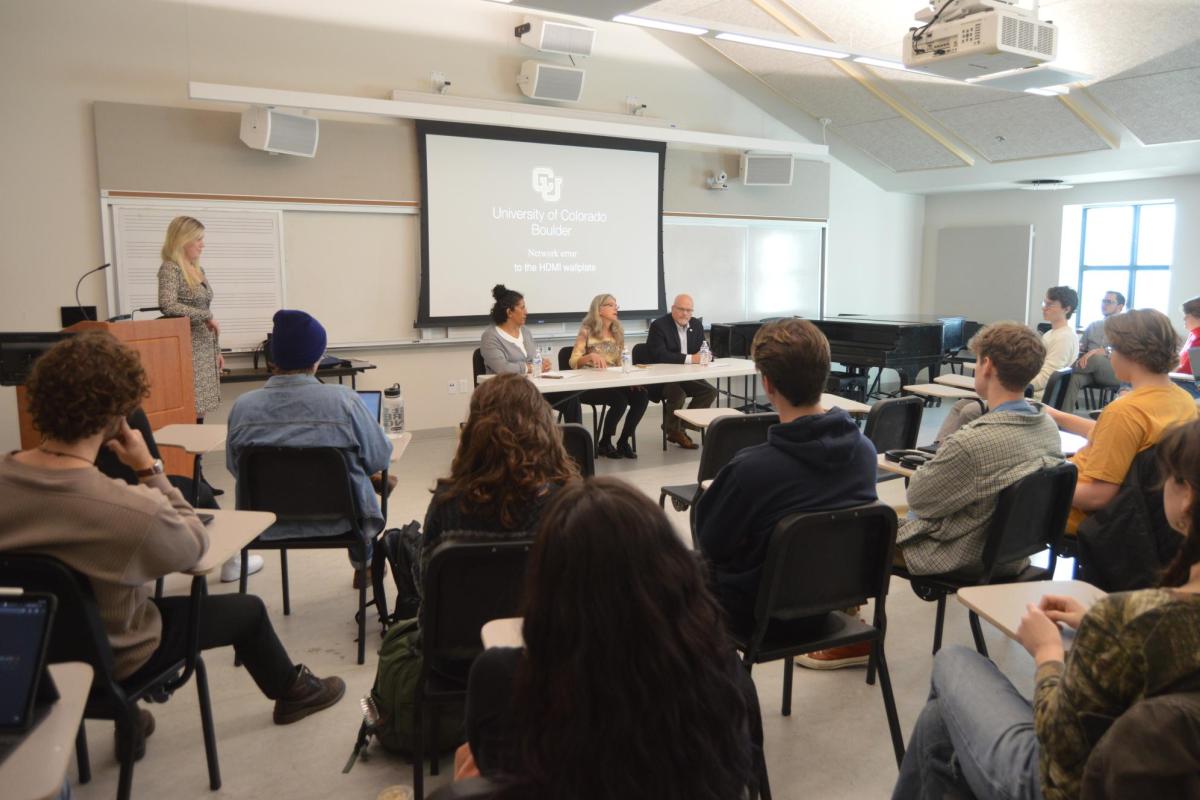 A classroom with students and a guest panel