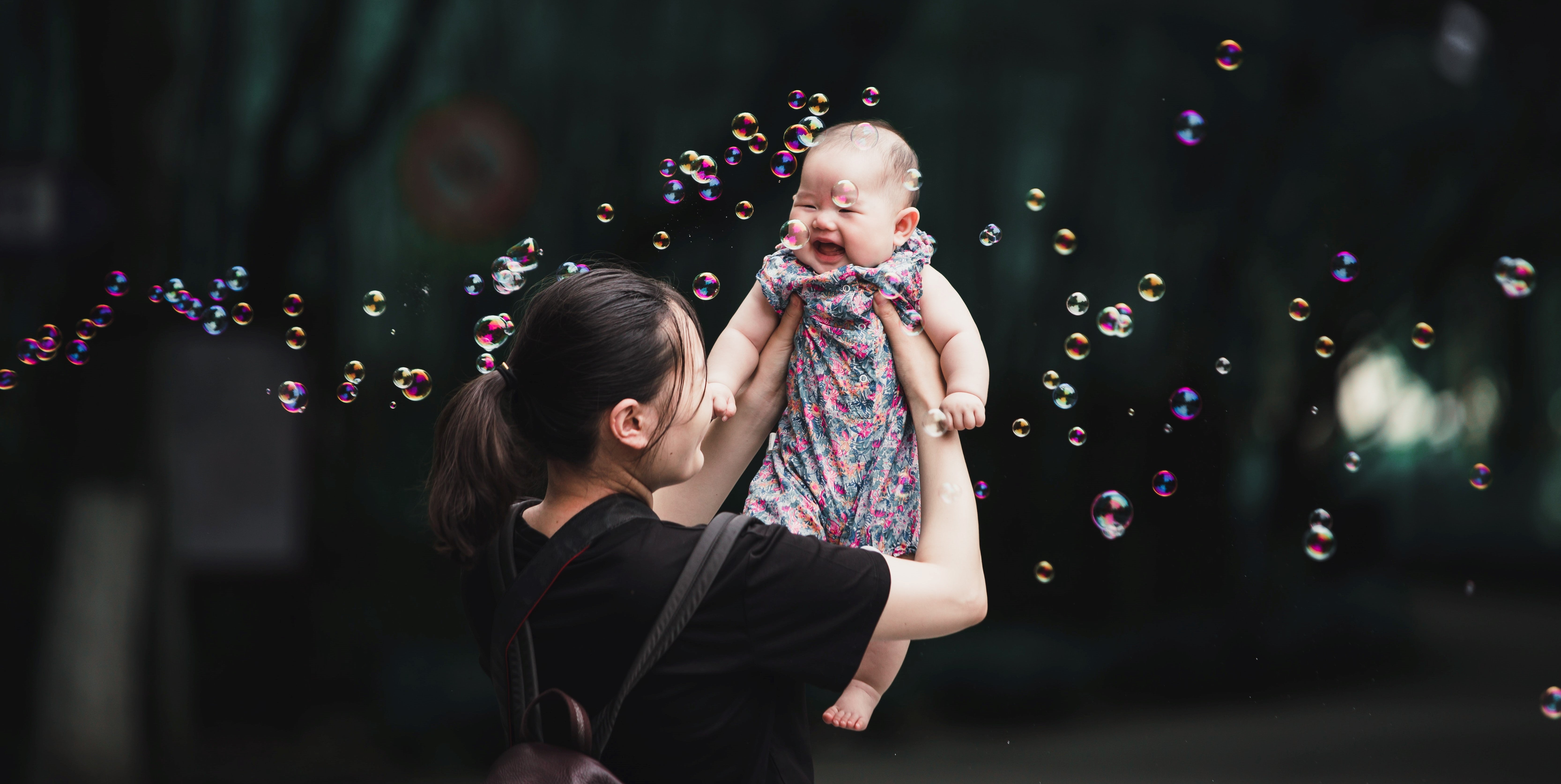 baby held up in bubbles