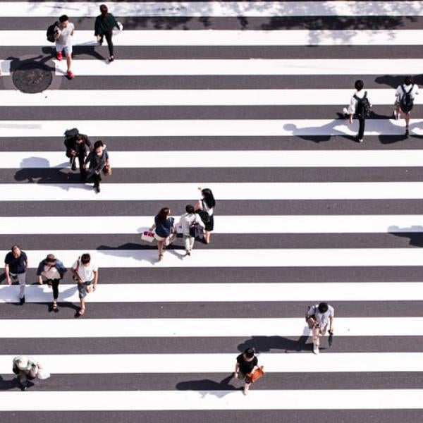 crowds of people walking on a striped surface