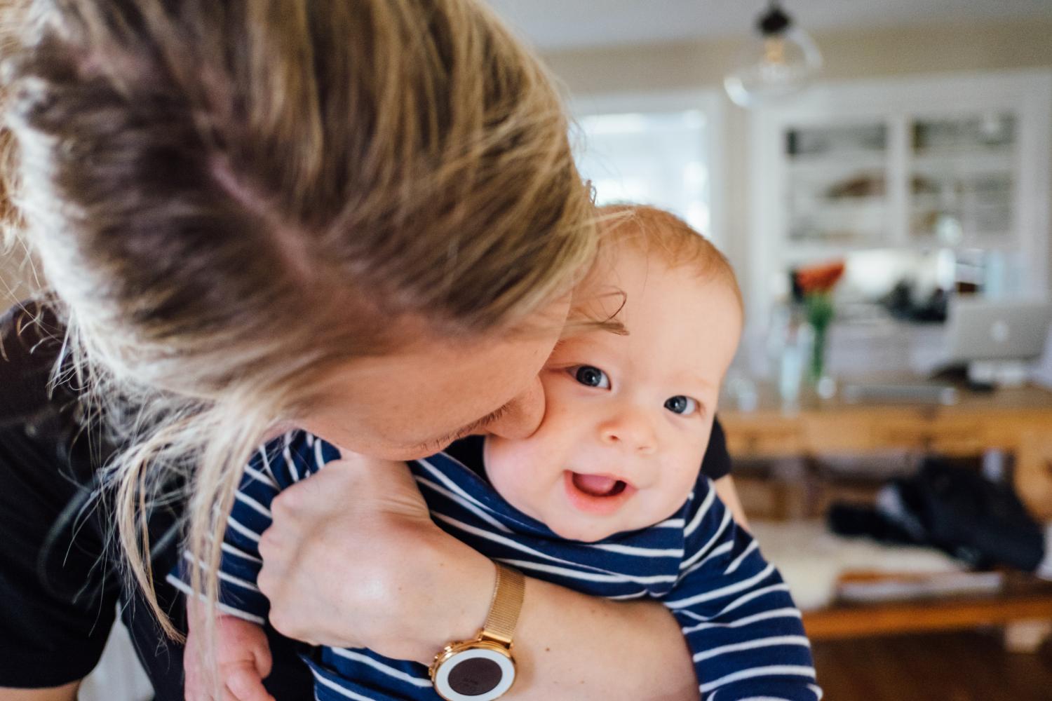 mother kissing infant