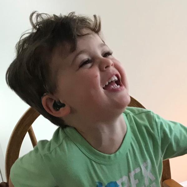 toddler sitting in chair and smiling