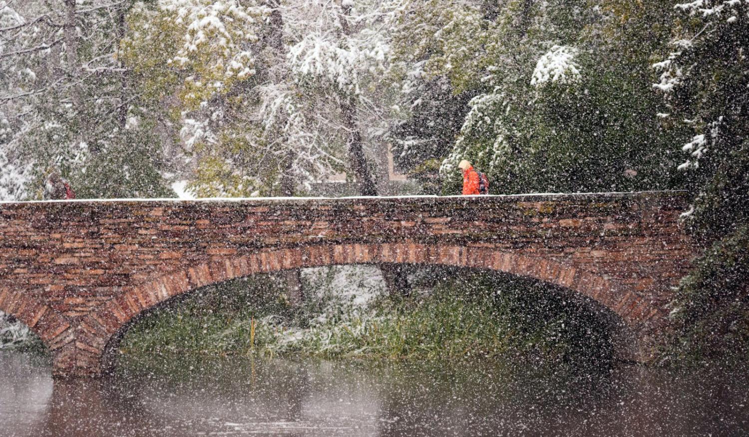 Snow falls as pedestrian crosses Varsity Bridge
