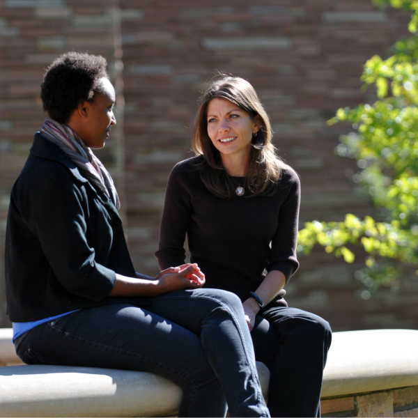 Two people talking on bench