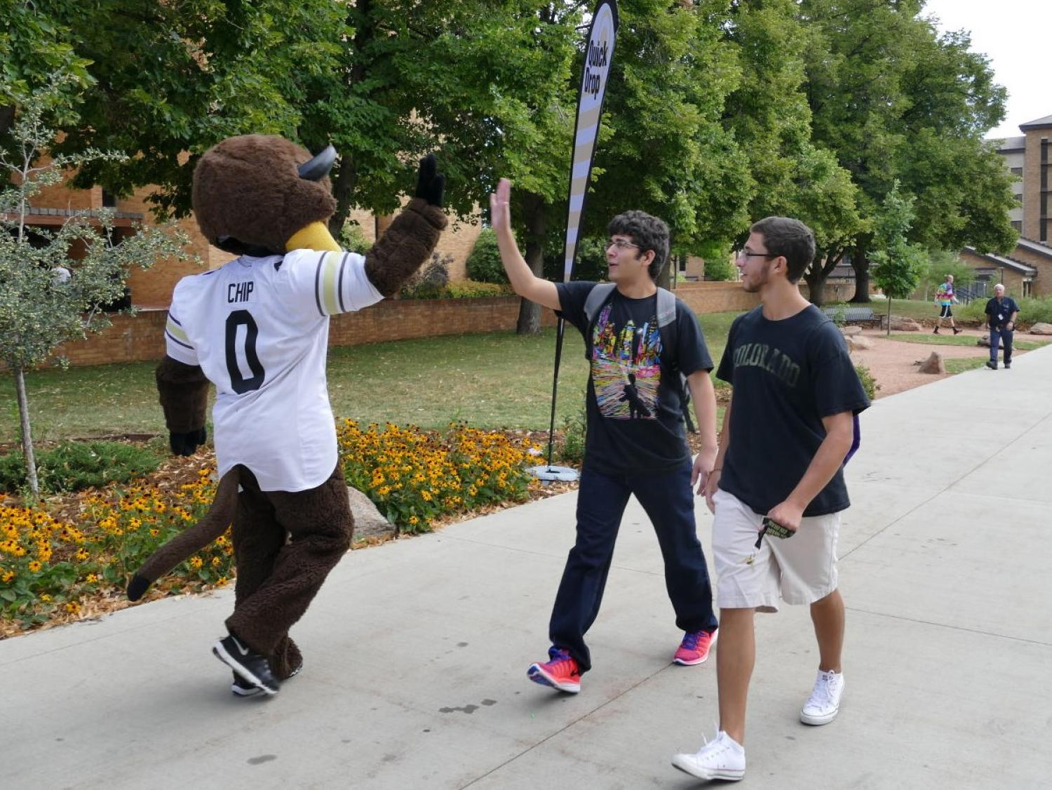 CU Mascott high fives a CU Boulder students on move in day