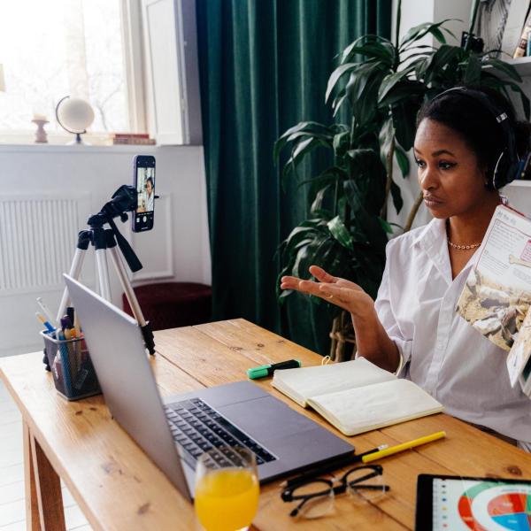 a person teaches online from a home office using a variety of technology