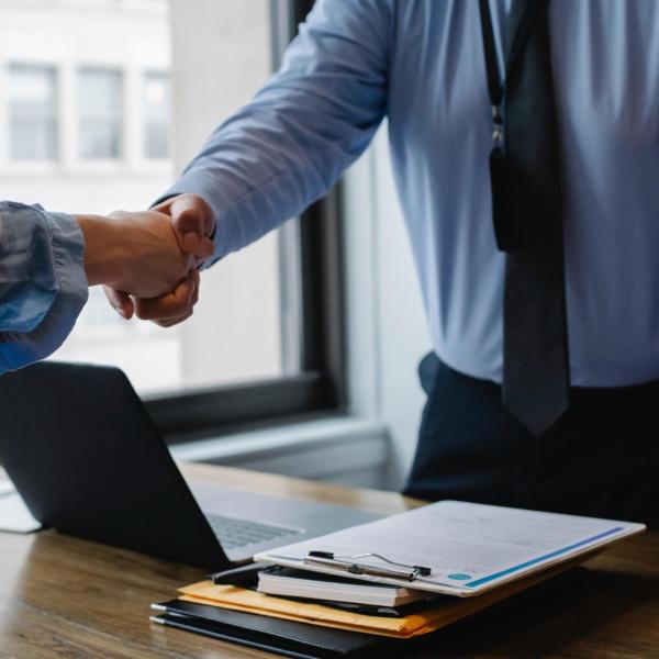 two people shake hands over a business deal