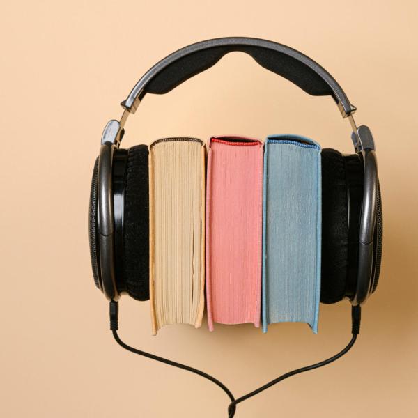 a pair of headphones sits around three books