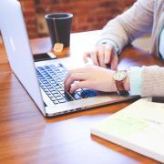 Person's hands shown working at a laptop