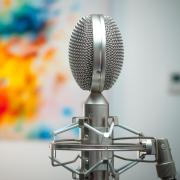 silver microphone with colorful splash on paint in the background