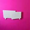 two chat bubbles floating over a pink background