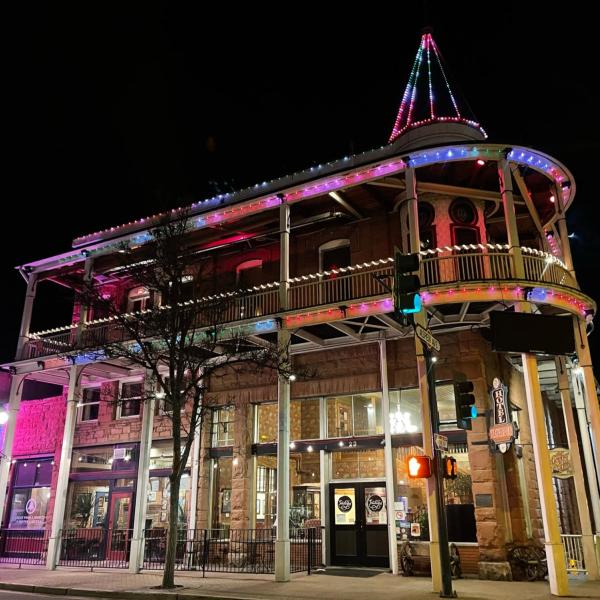 The Weatherford Hotel in Flagstaff, Arizona, glows at night with strings of lights of various colors.