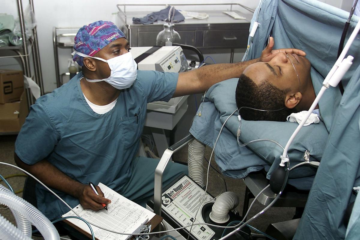 Anesthesiologist monitors patient.