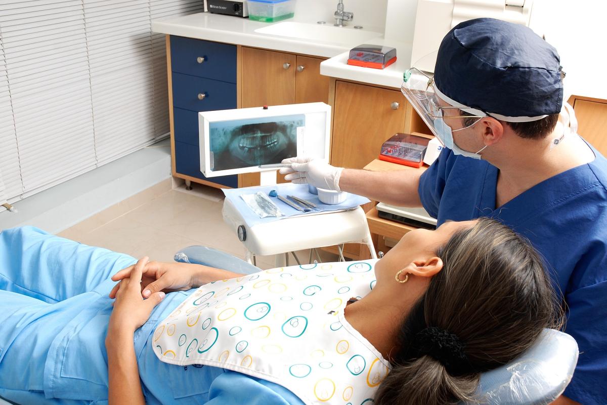 Dentist shows patient an x-ray.