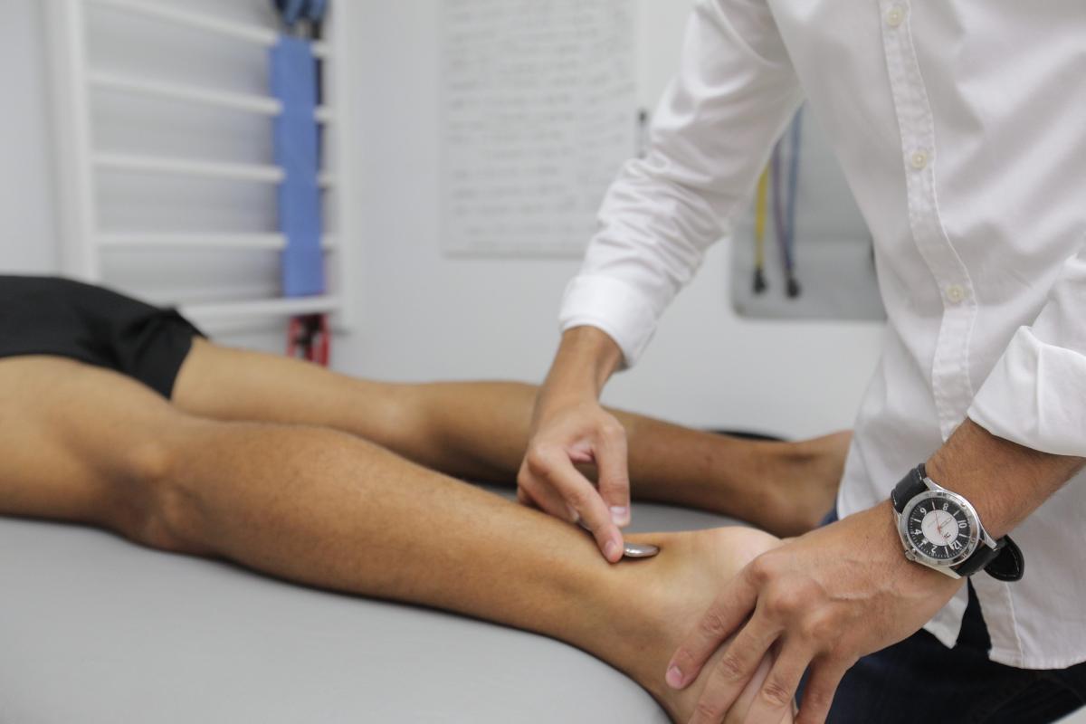 Physical Therapist works on patient's leg.