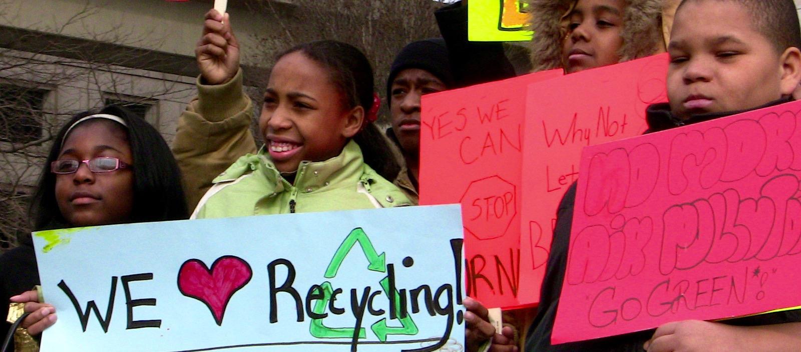 Youth holds signs at a demonstration against a waste incinerator in Detroit