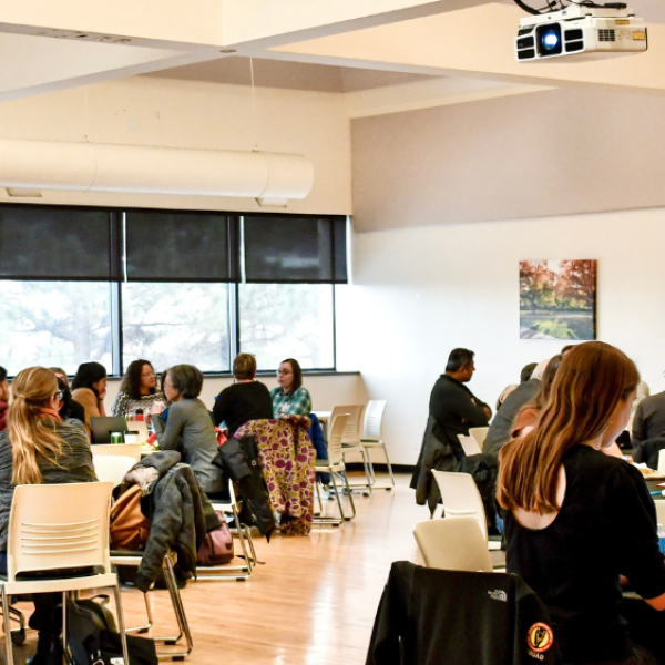 group of people sitting in a room, at roundtables