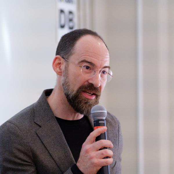 Caleb Elfenbein holding a microphone