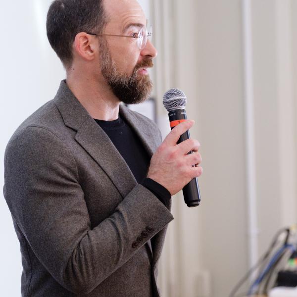 Caleb Elfenbein holding a microphone