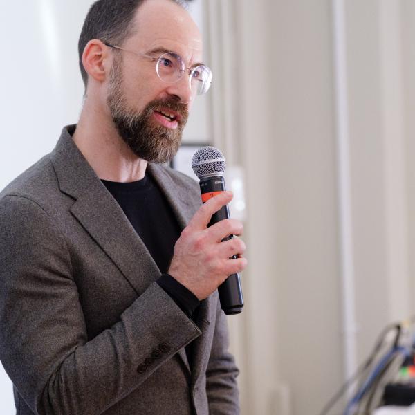 Caleb Elfenbein holding a microphone