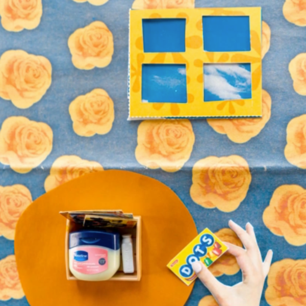 Blue background with yellow roses and a hand with a box of candy