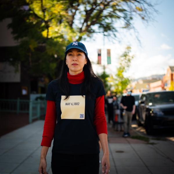 Angie Eng, who is the organizer of the event, is scene in red and black with a shirt marking the date "May 6, 1882".