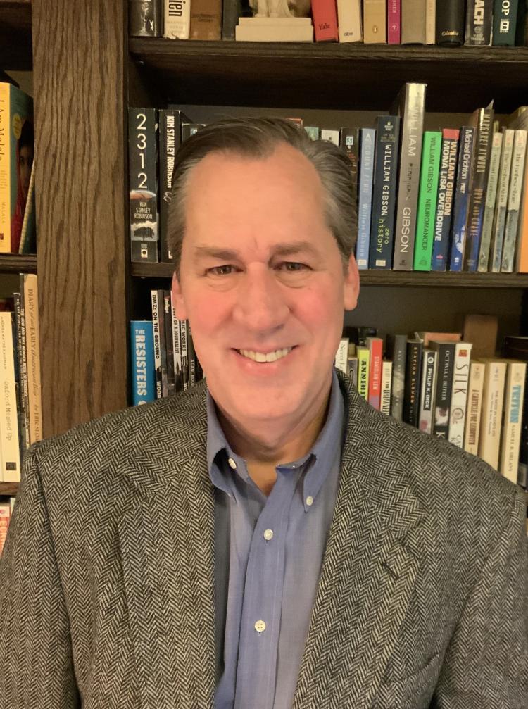 Man smiling in front of bookcase
