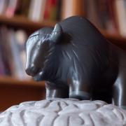 A buffalo toy in front of a bookshelf