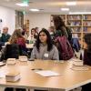 Group discussions from the Center for Humanities & the Arts salon event in February 2023, topic is "Future of Arts and Humanities". A group of people around a table discussing and chatting.