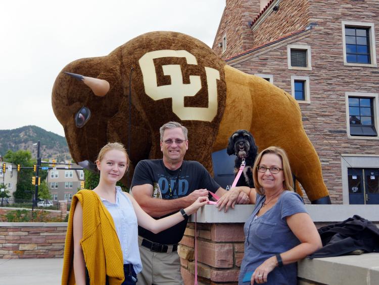  Lauren Taylor, freshman geology major from Chicago, has her picture taken with es a photo of her dad, Stan; mom, Susanne; and Coco, in front of the UMC. 